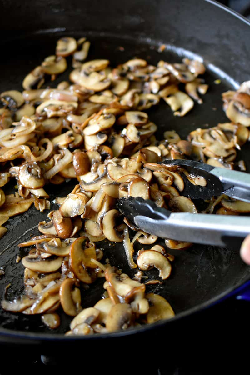 Close up of sautéed mushrooms in a large skillet. 