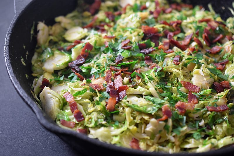 A close up side view of Shaved Brussels Sprouts with Bacon.