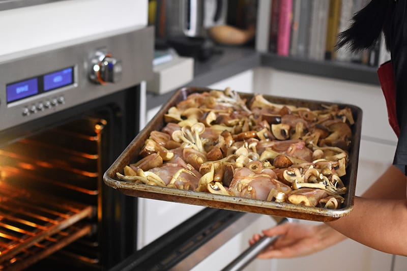 Pop the tray of Sheet Pan Chicken and Mushrooms into a hot oven.