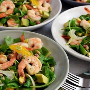 A closeup of four shallow bowls filled with shrimp and avocado salad