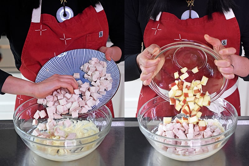 Adding cubed cooked chicken and apples to the bowl of mayonnaise dressing.