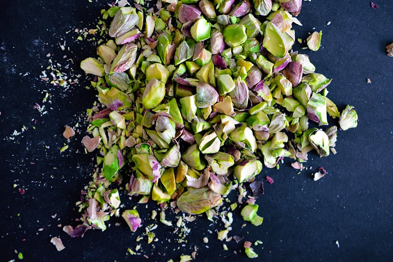 Overhead shot of crushed and chopped pistachios ready for the Watercress with Seared Prosciutto and Peaches.