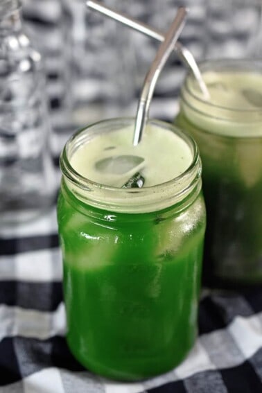 An overhead shot of a mason jar filled with emerald green cold brew matcha.