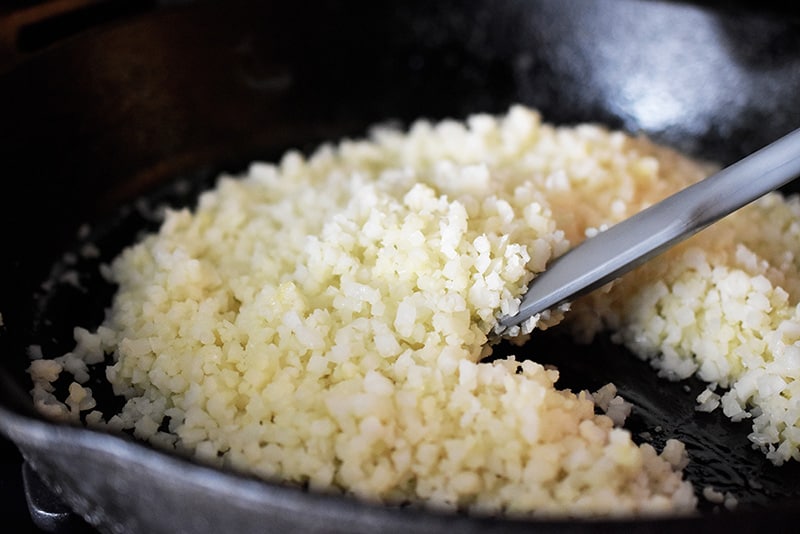 Stir-frying Simple Cauliflower Rice in a cast iron skillet