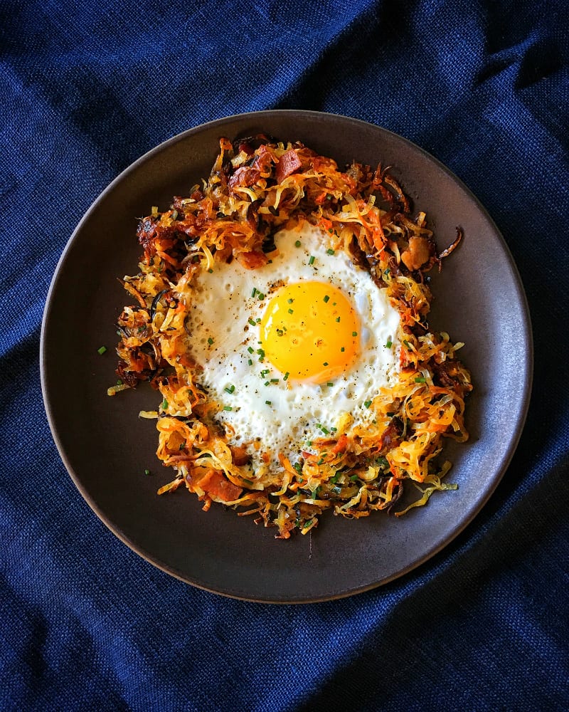 An overhead shot of a fried egg in a Crispy Swoodles with Bacon nest!