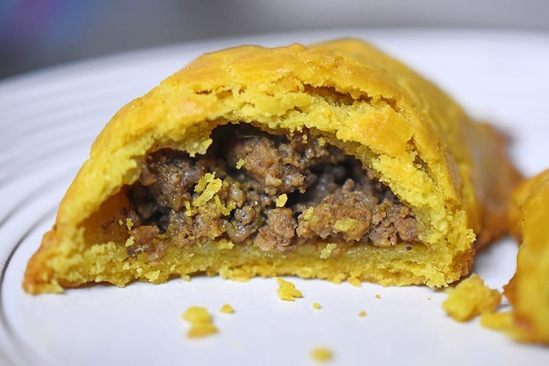 A Paleo Curried Meat Pie on a plate, cut in half.