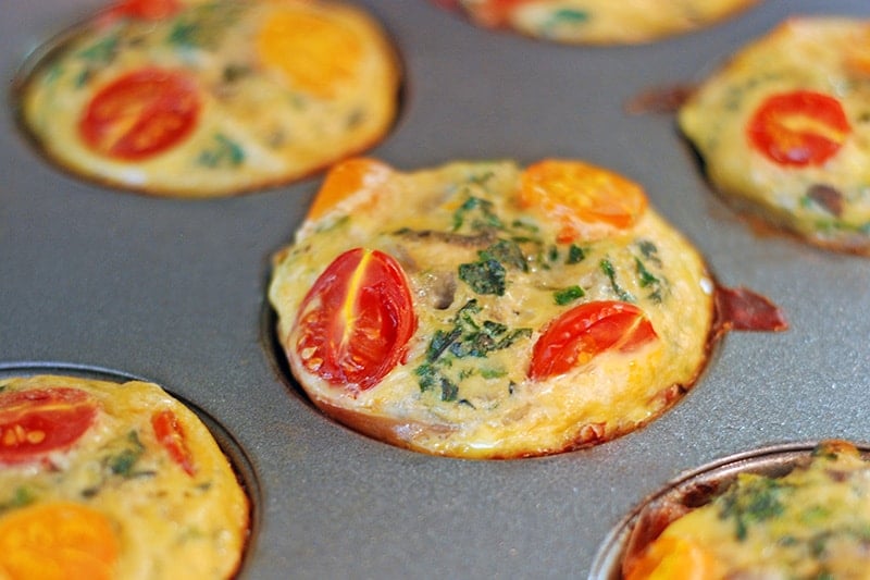 A closeup photo of Prosciutto-Wrapped Mini Frittata Egg Muffins in a muffin tin.