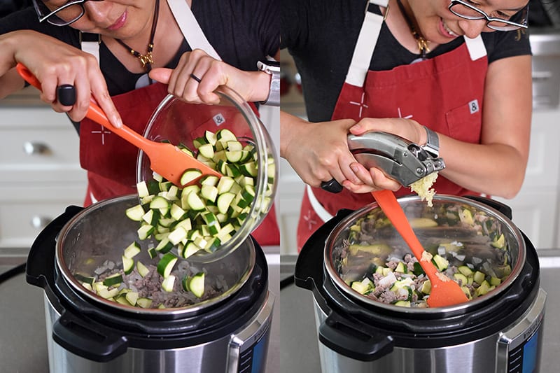 A shot of cut zucchini and minced garlic being added to an open Instant Pot.