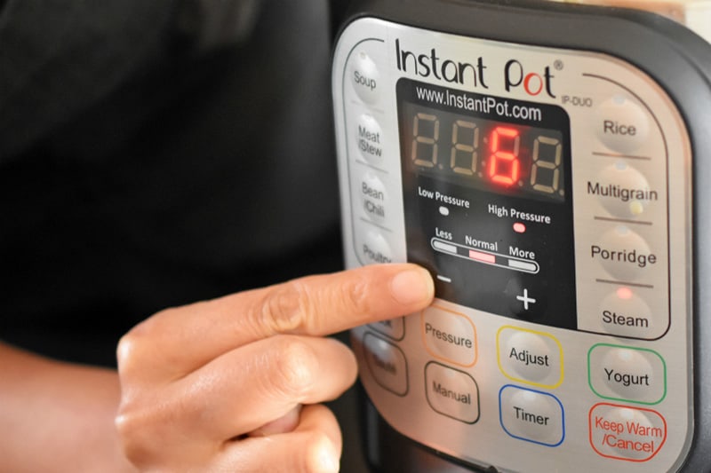 A hand is shown programming an Instant Pot Duo to cook for 6 minutes under high pressure.