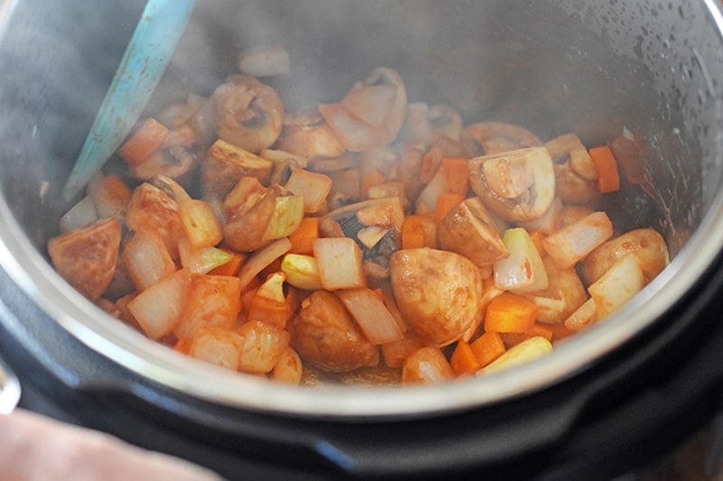 Sauteeing the ingredients of Instant Pot Summer Italian Chicken with some tomato paste.