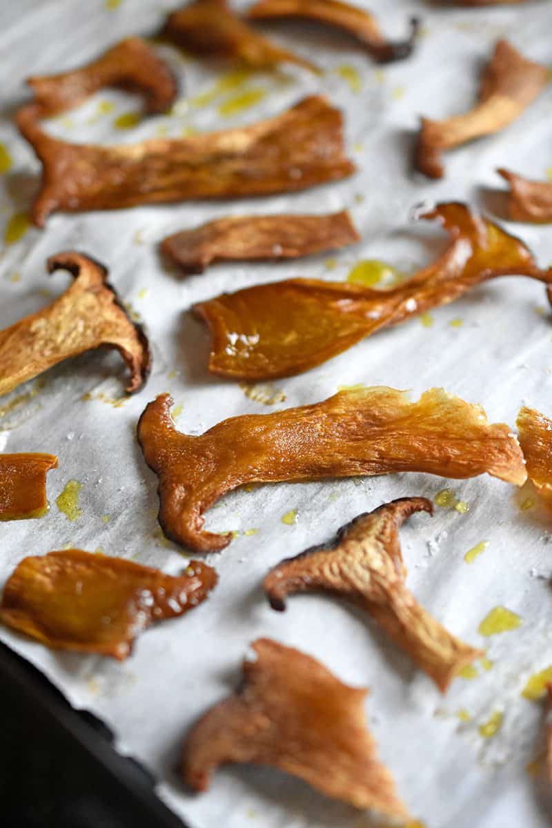 Thinly sliced mushrooms on a sheet tray baked and crisped.