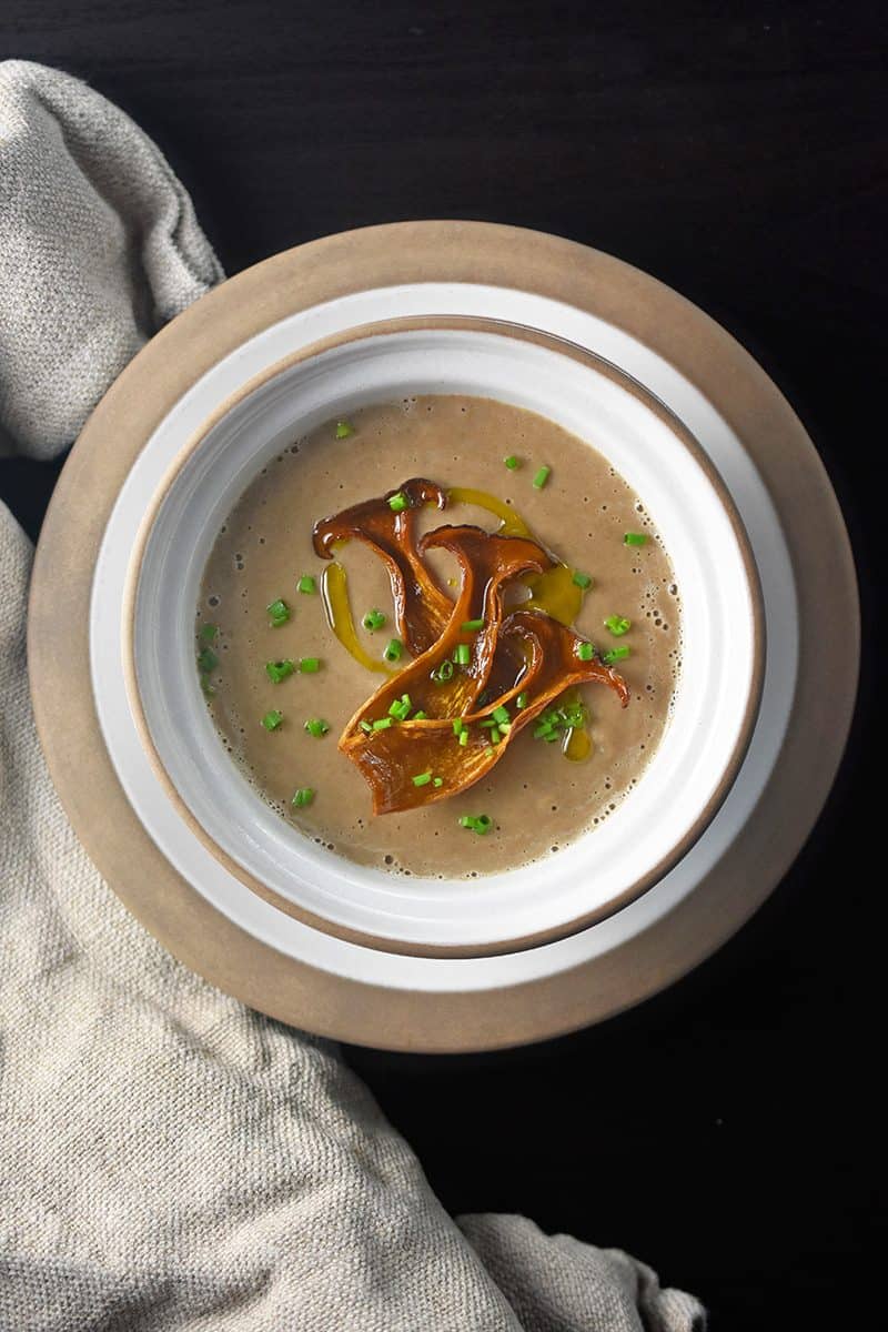 A bowl of Instant pot cream of mushroom soup topped with mushrooms.