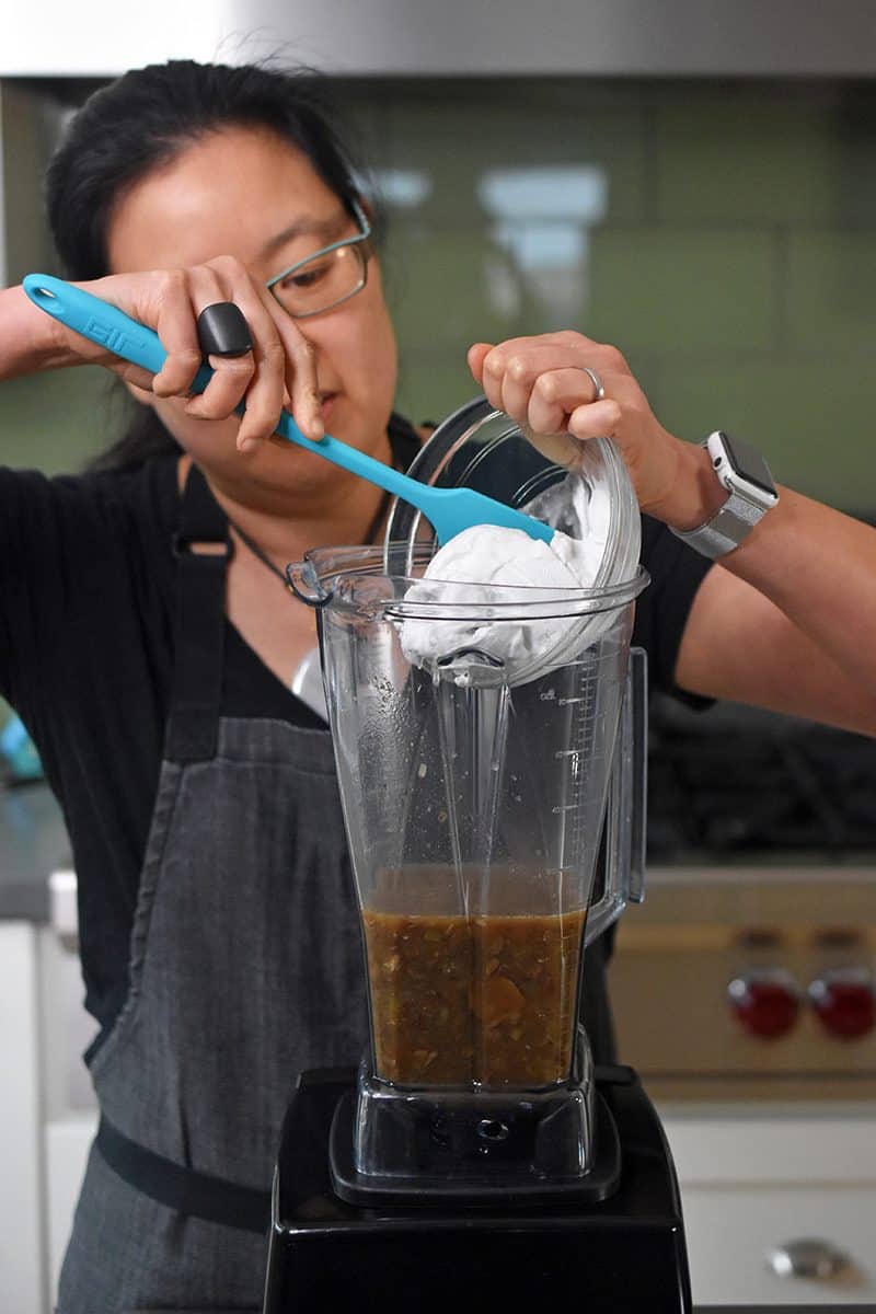 Adding coconut cream to the high speed blender.