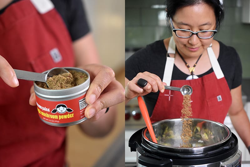 A spoonful of Nom Nom Paleo's Magic Mushroom Powder is added to an open Instant Pot.