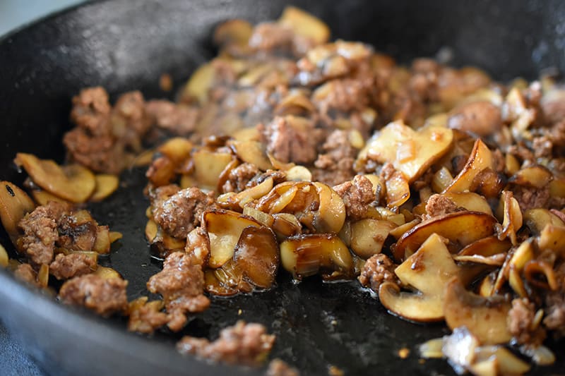 Closeup of the cooked ground beef and vegetables in the cast iron skillet.
