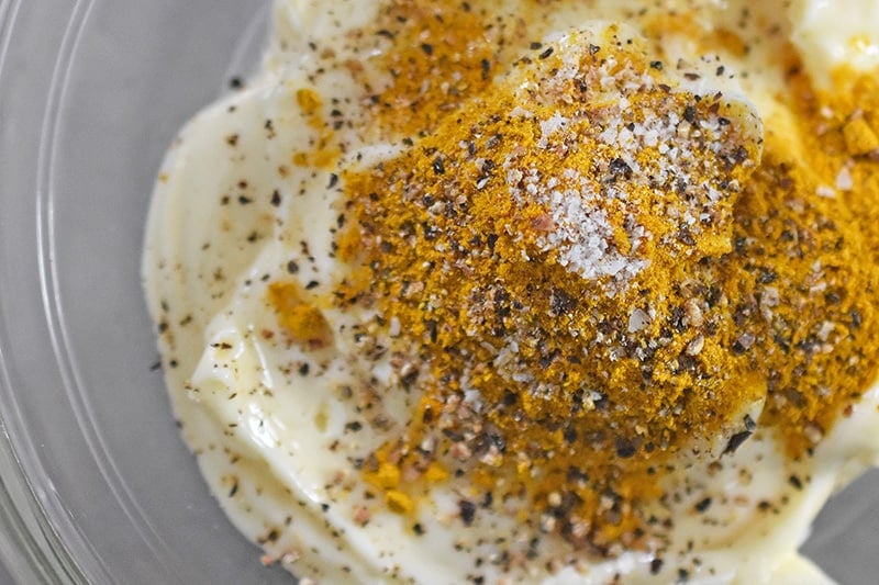 A bowl of curried mayo for a curry chicken salad recipe.