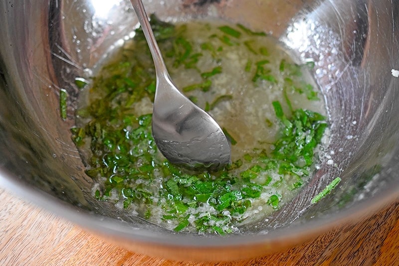 Stirring the marinade for Sheet Pan Pork Chop Supper with a spoon