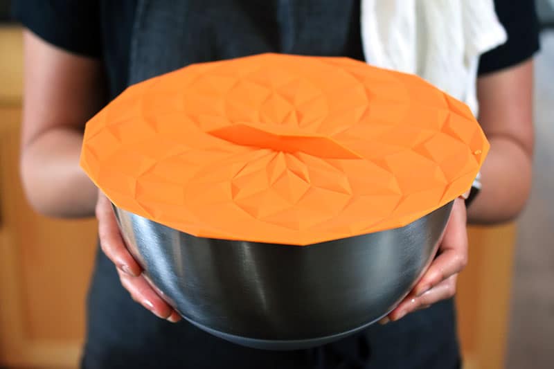 A large silver mixing bowl covered with a silicone lid.