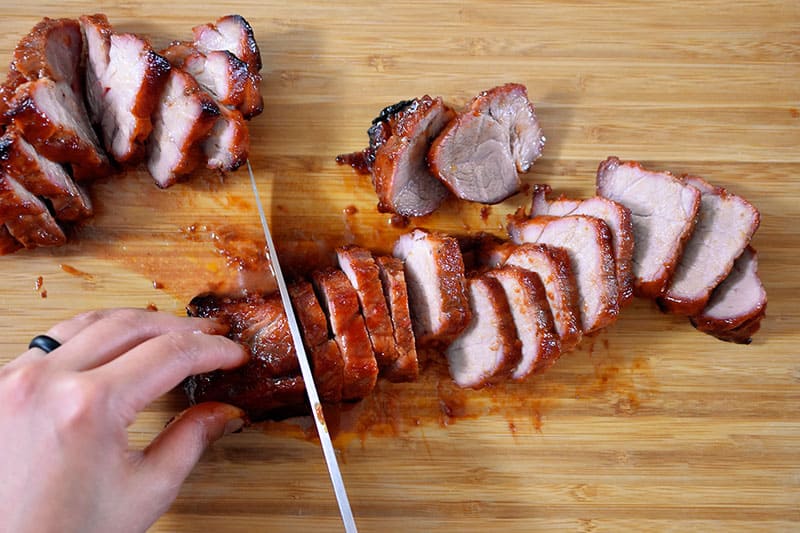 Paleo Char Siu (Chinese BBQ Pork) sliced into 1/2-inch pieces on a wooden cutting board.