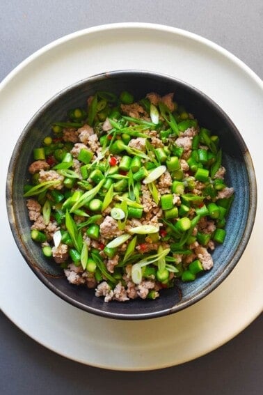 An overhead shot of Spicy Pork and Asparagus Stir-Fry in a blue serving bowl.