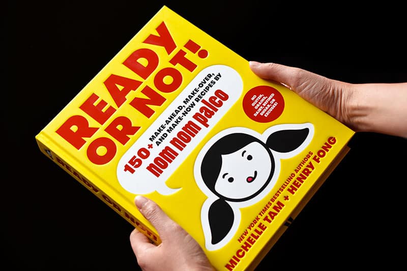 Two hands holding Ready or Not! cookbook by Michelle Tam and Henry Fong 