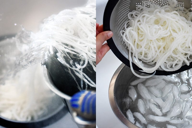 Someone draining the daikon noodles from the pot and placing them in an ice water bath.