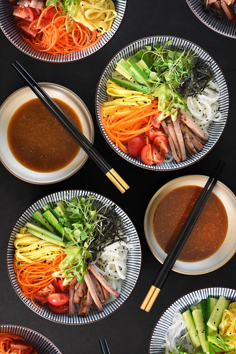 Several bowls of hiyashi chuka surrounded by bowls of paleo and soy-free dipping sauce.