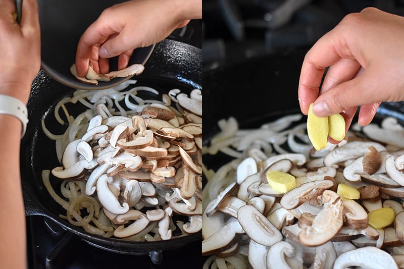 Adding thinly sliced shiitake mushrooms and ginger slices to a cast iron skillet filled with cooked onions. 