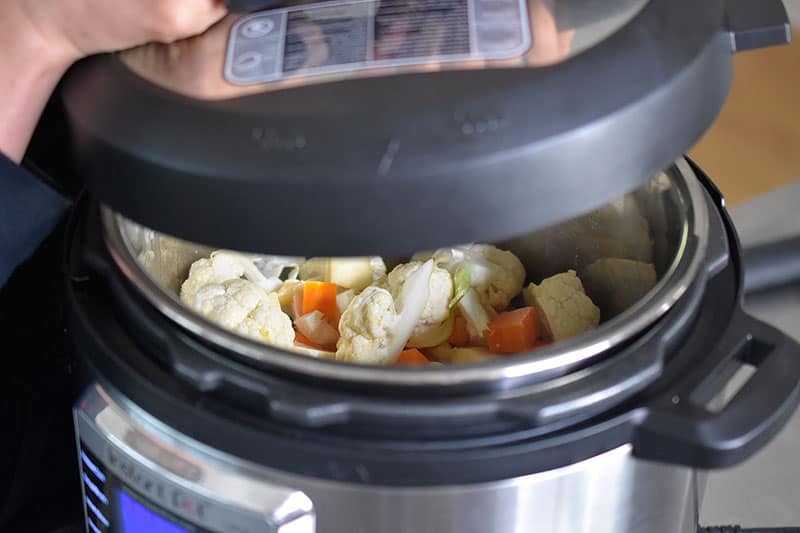 Someone putting the lid of the Instant Pot on.