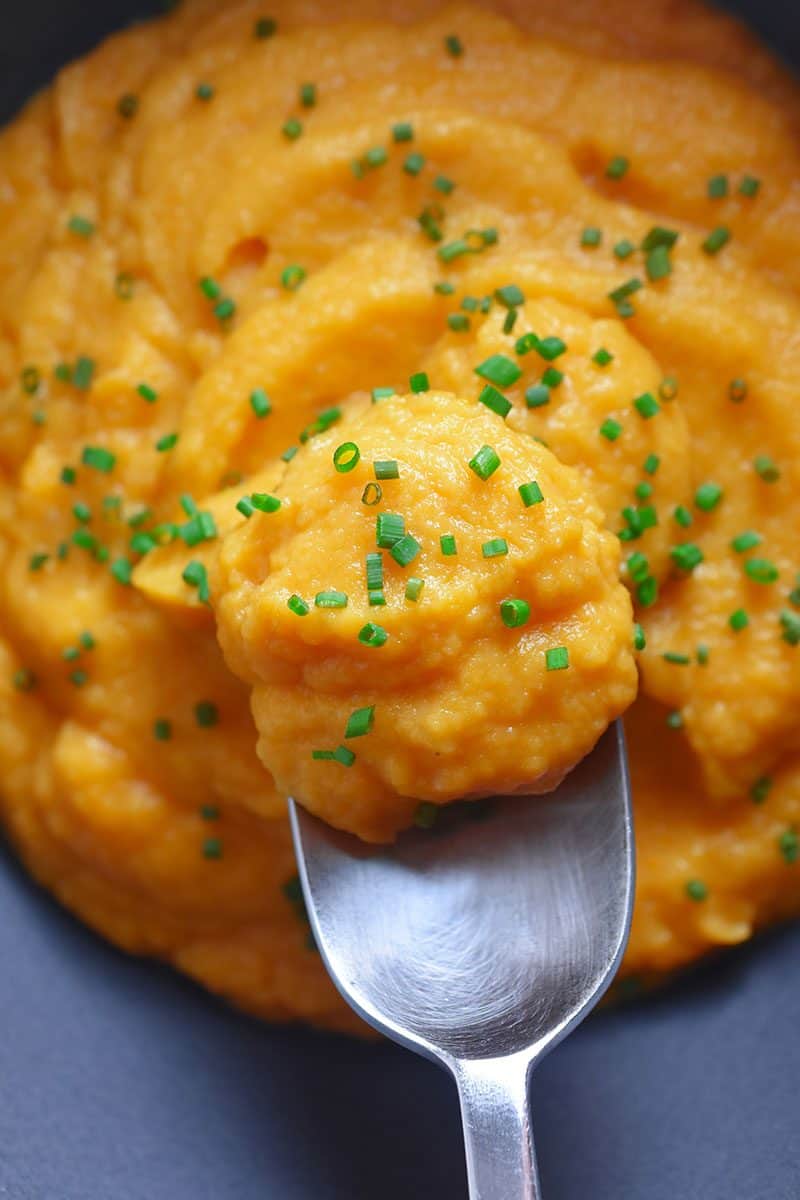 A spoon lifting out a scoop of autumn mash.