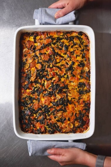 An overhead shot of a white casserole dish filled with Italian Sausage and Kale Casserole, a Whole30 and low carb weeknight dinner