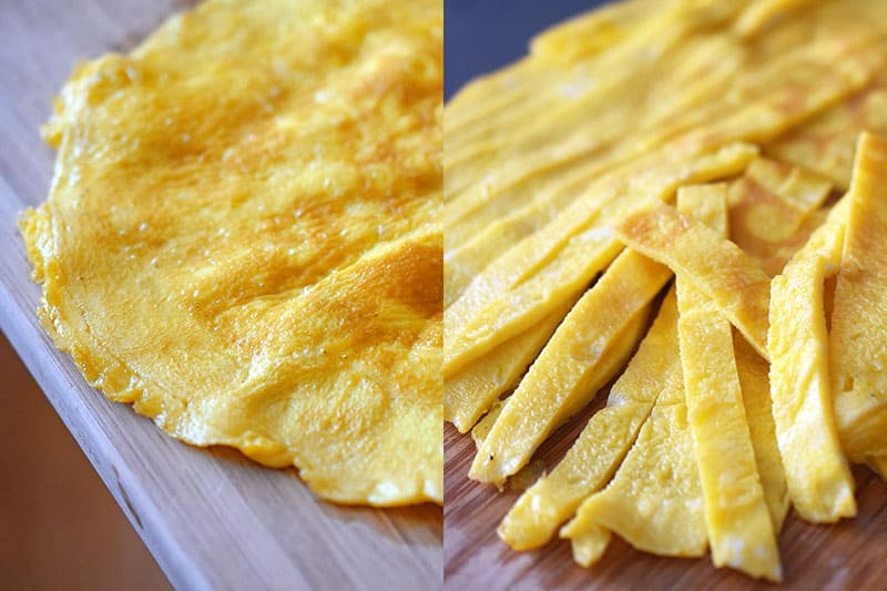 Cooked egg on a cutting board and sliced into thin strips.