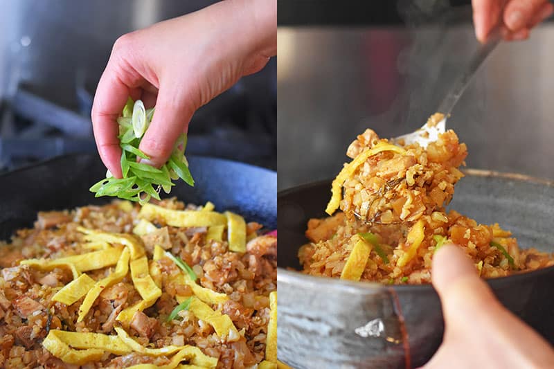 Someone adding sliced green onions to a pan.