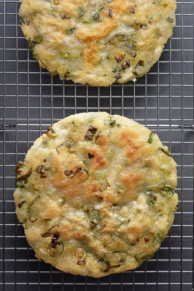 An overhead shot of two Paleo Scallion Pancakes on a wire cooling rack.