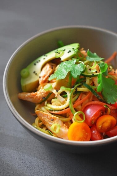 A beige bowl filled with Spicy Thai Chicken Zoodle Salad