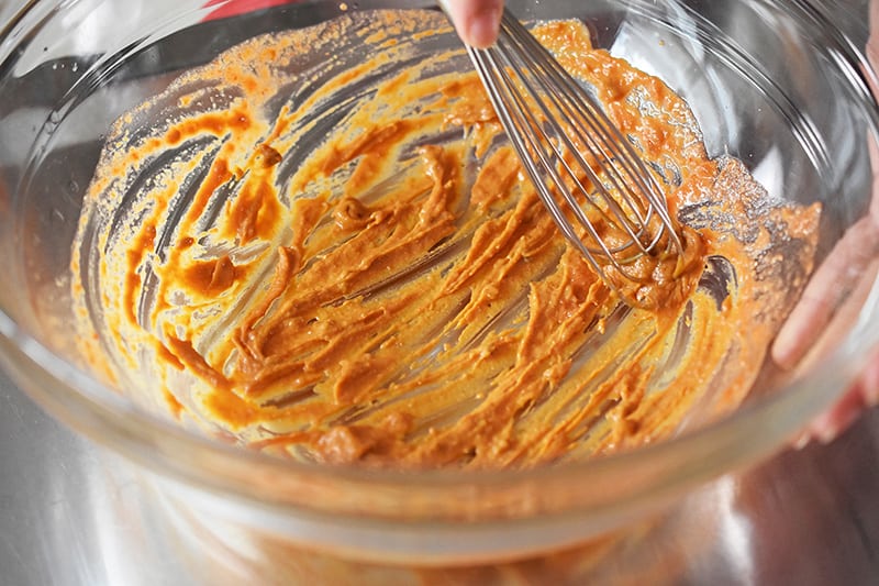 Whisking the sauce in a bowl.