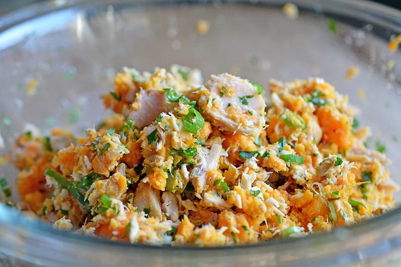 The ingredients for spicy tuna cakes mixed together in a bowl.