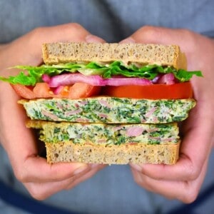 A closeup shot of someone holding a paleo St. Paul sandwich that has been sliced in half.