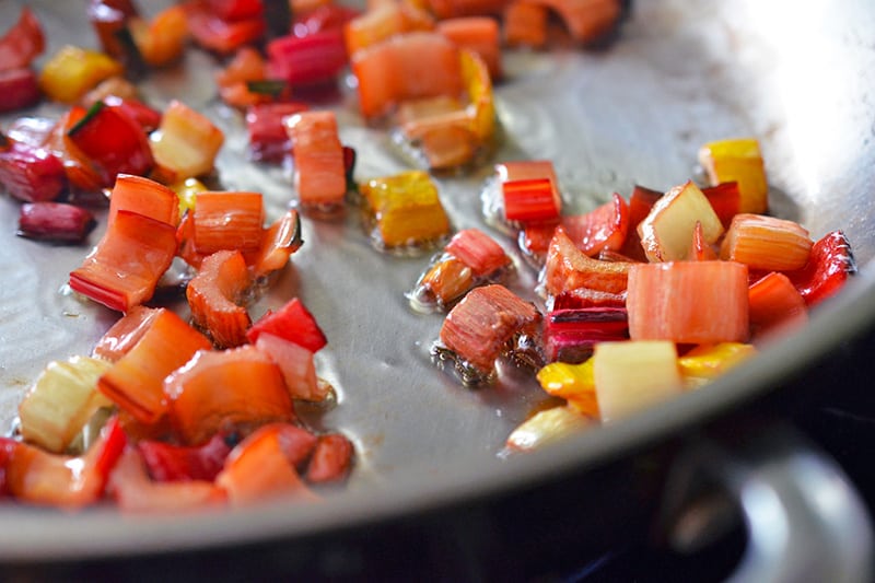 Sautéing swiss chard stems in a pan for a swiss chard salad.