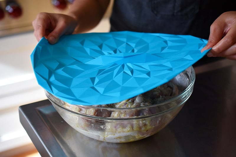 Covering the Vietnamese Lemongrass Chicken bowl with a silicone lid