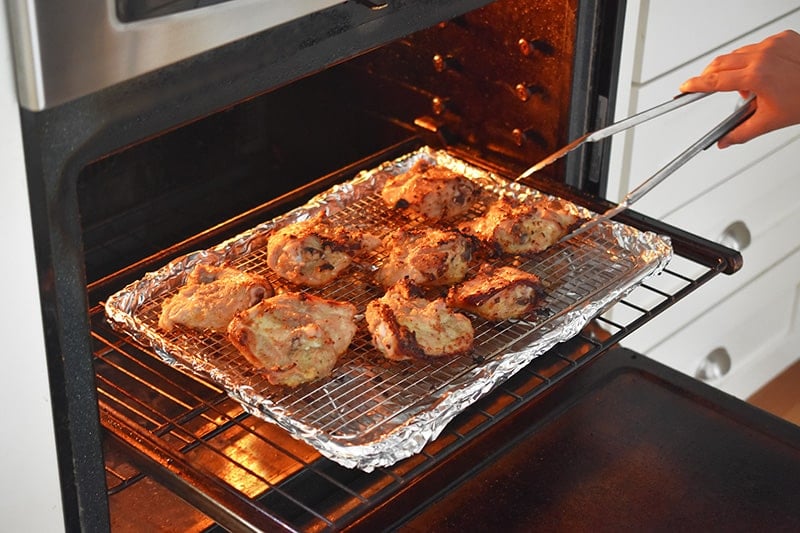 Flipping the Vietnamese Lemongrass Chicken skin side up in the oven.