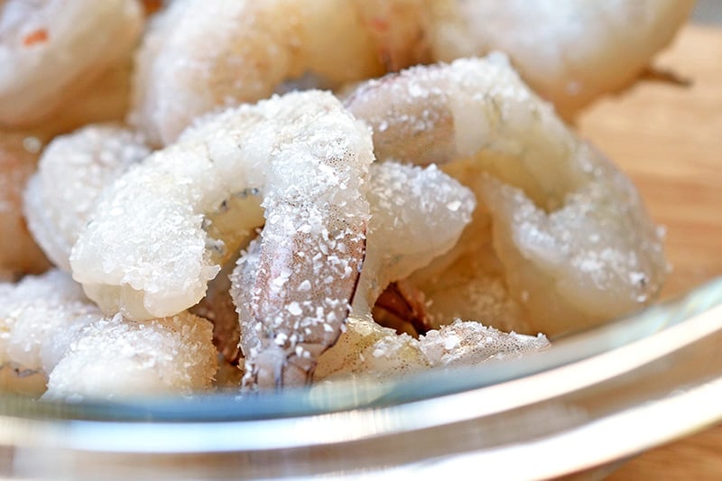 Close up shot of raw shrimp seasoned with salt. 