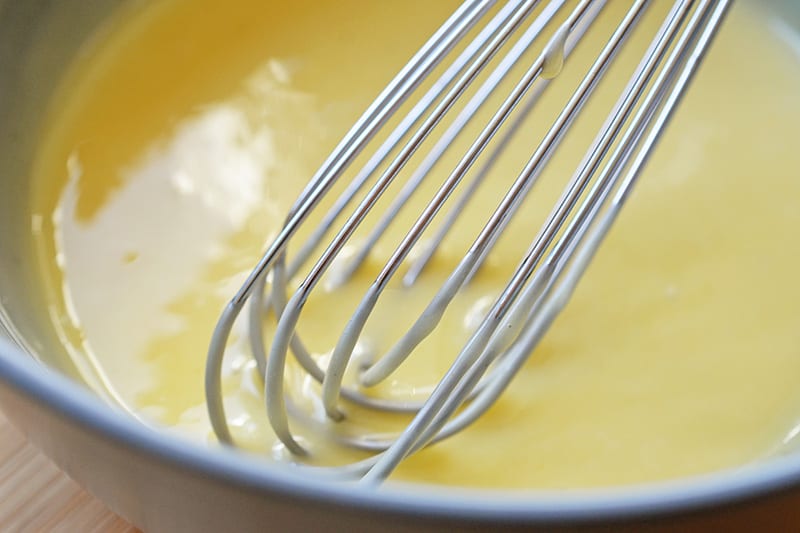 An overhead shot of a bowl filled with the light yellow sauce for Paleo Walnut Shrimp 