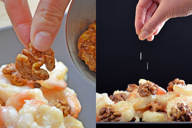 Adding the maple spiced walnuts and toasted sesame to a platter of Paleo Walnut Shrimp 