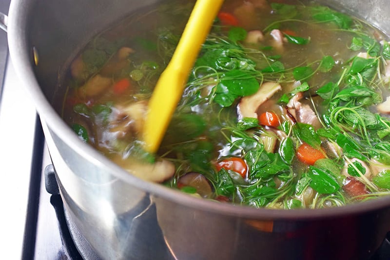An overhead shot of a pot of Watercress & Chicken Soup.