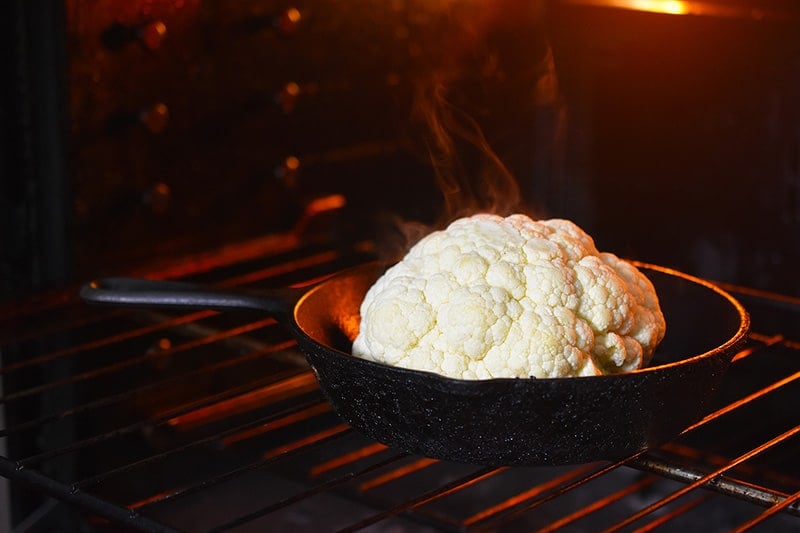 The foil cover is removed and the cauliflower finishes cooking in the oven.