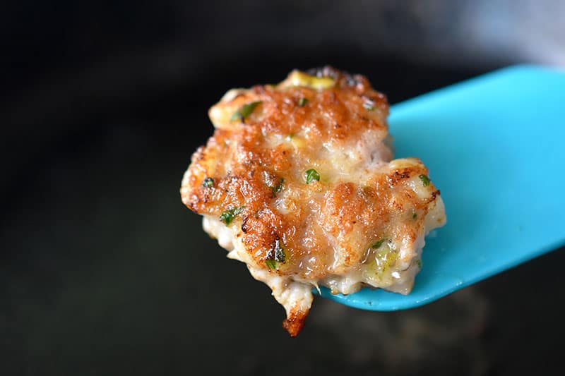 Frying a small patty of the Wonton Meatball mixture to check for seasoning.