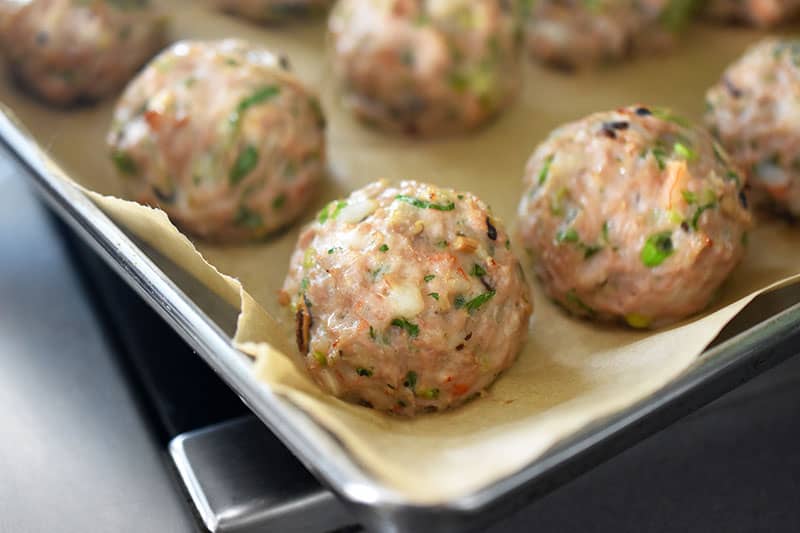 A closeup of a baked tray of Wonton Meatballs 