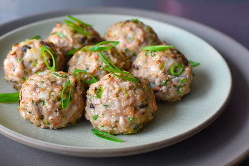 A sideview of a plate of Wonton Meatballs 