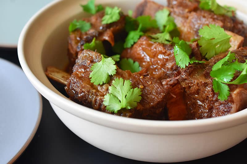 A closeup shot of a serving bowl filled with Instant Pot Korean Short Ribs